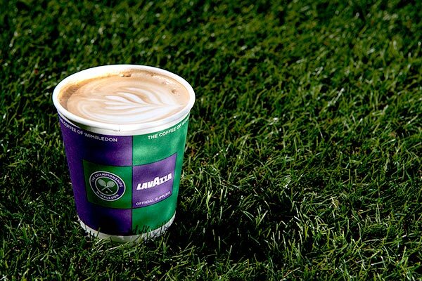 A coffee in a paper cup on grass