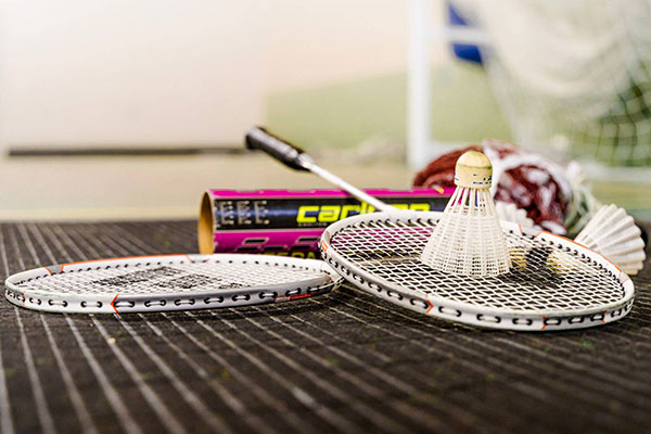 Badminton equipment sits on the floor inside a hall